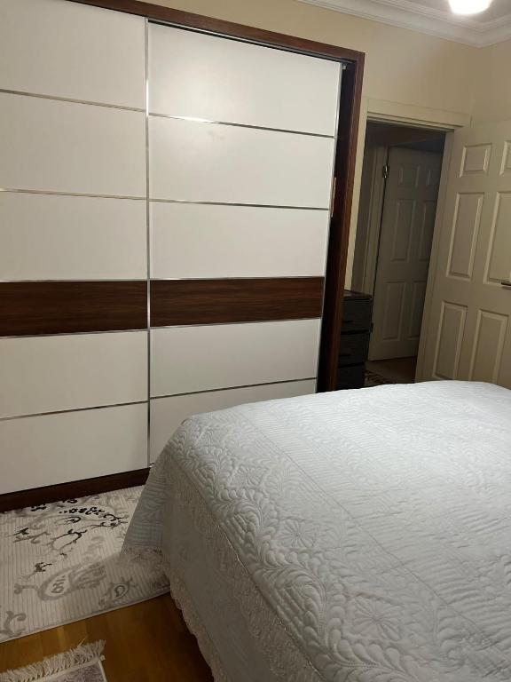 a bedroom with a white bed and a dresser at Gulev in Istanbul