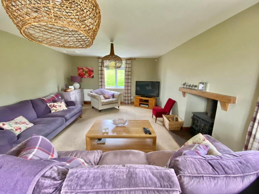 a living room with a purple couch and a table at Belle Vue, 5 bedroom house in Cockermouth