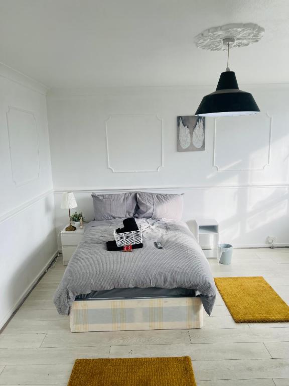 a white bedroom with a bed with a black lamp at Elegant Downtown Escape in London