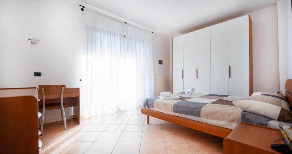 1 dormitorio con cama, escritorio y ventana en La Maison di Angelina - Appartamento vista Lago, en Sirmione