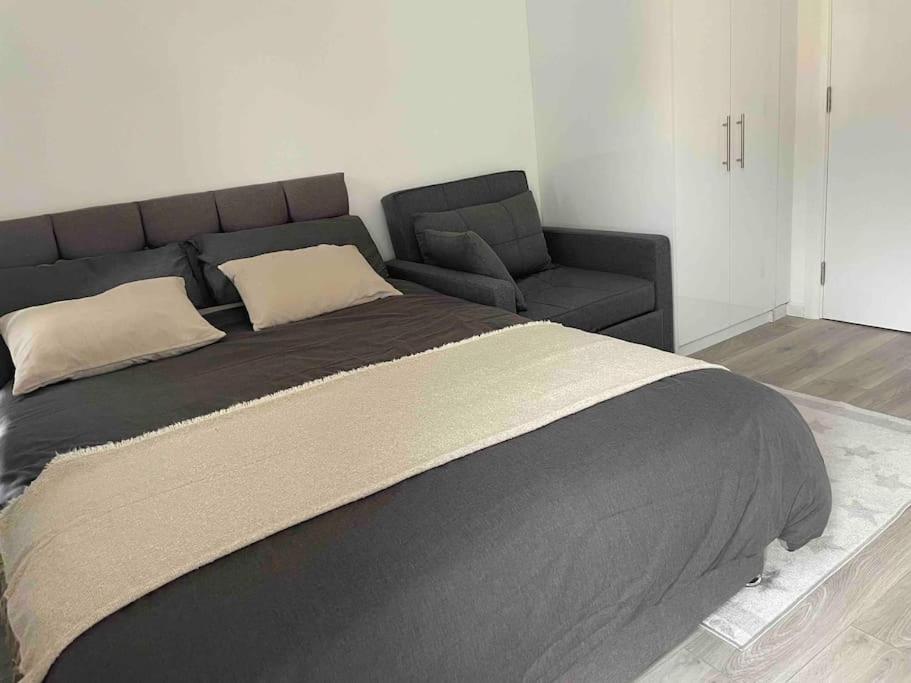 - un lit et un canapé dans une chambre dans l'établissement Studio Flat Private Shower Wc and Kitchenette, à Londres