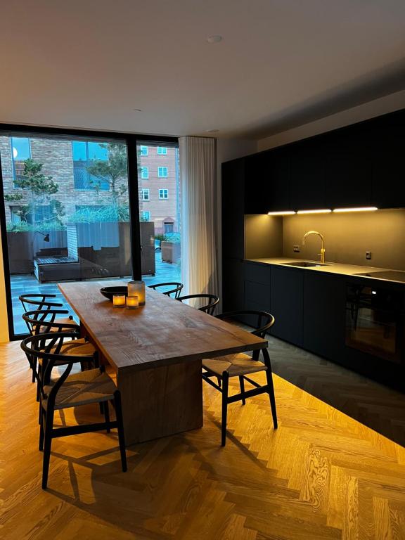 a kitchen with a large wooden table and chairs at Boutique City Apartment Aarhus in Aarhus