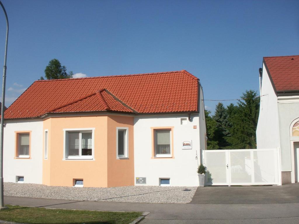 Casa blanca y naranja con techo rojo en Gästehaus Bett-i, en Marchegg