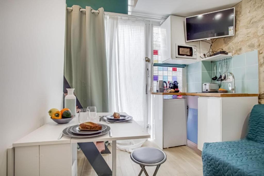- une petite cuisine avec une table et de la nourriture dans l'établissement Tiny boutique studio in Paris 11, à Paris
