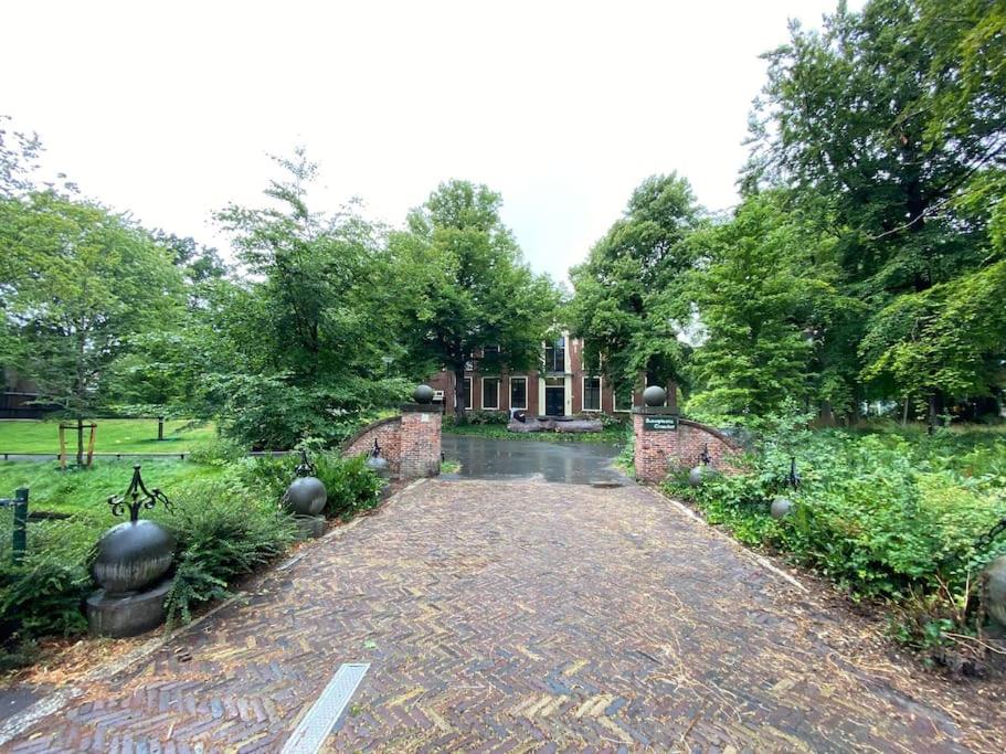 una entrada de ladrillo que conduce a una casa con árboles en Nette maisonnette in groene rustige wijk, en Rijswijk