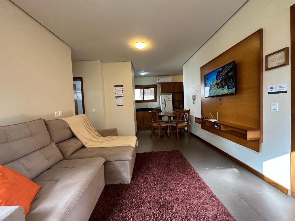 Apto Rua Coberta Gramado في غرامادو: غرفة معيشة بها أريكة وطاولة