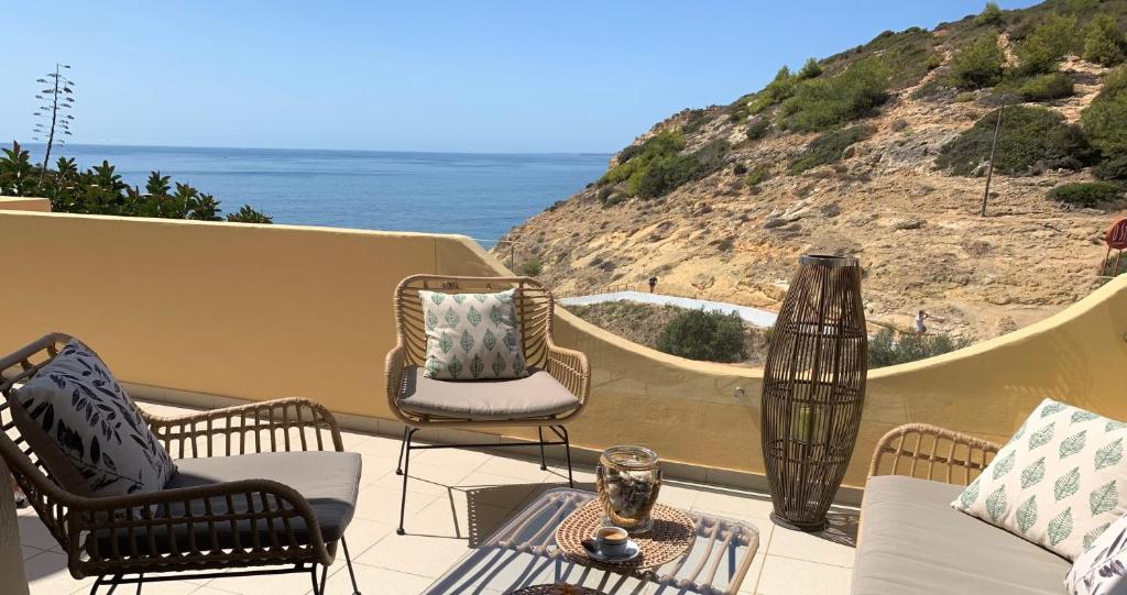 une terrasse avec des chaises et une table et l'océan dans l'établissement Ver-O-Mar, à Carvoeiro