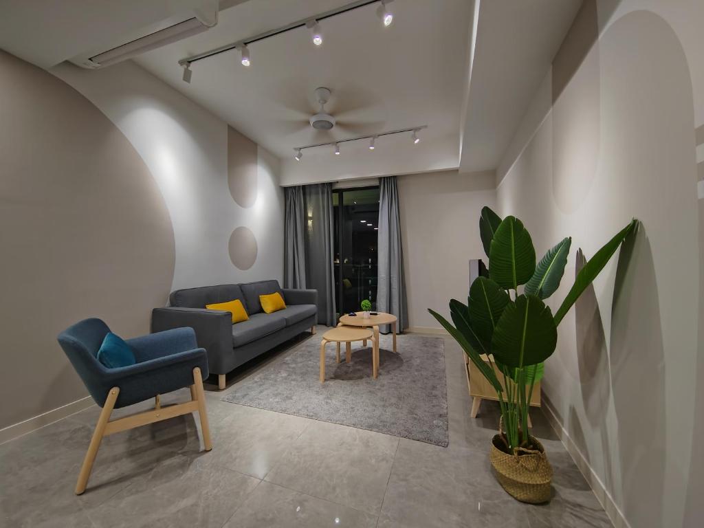 een woonkamer met een bank, een stoel en een tafel bij The Ooak Suites @ 163 Building (Mont Kiara) in Kuala Lumpur