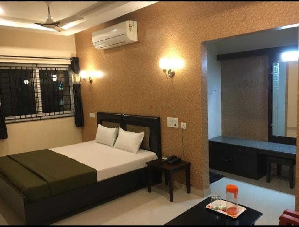 a hotel room with a bed and a mirror at Vinayagam Residency in Arcot