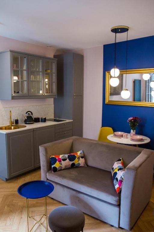 a living room with a couch and a kitchen at HOLI in Toruń