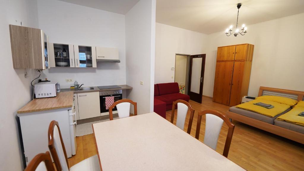 eine Küche und ein Wohnzimmer mit einem Tisch und Stühlen in der Unterkunft CozyNite Premium Apartment Hernals 1 in Wien