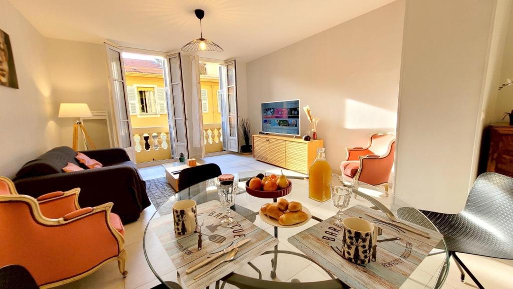 un salon avec une table en verre et une télévision dans l'établissement Ze Perfect Place - Charmant appartement - Masséna, à Nice