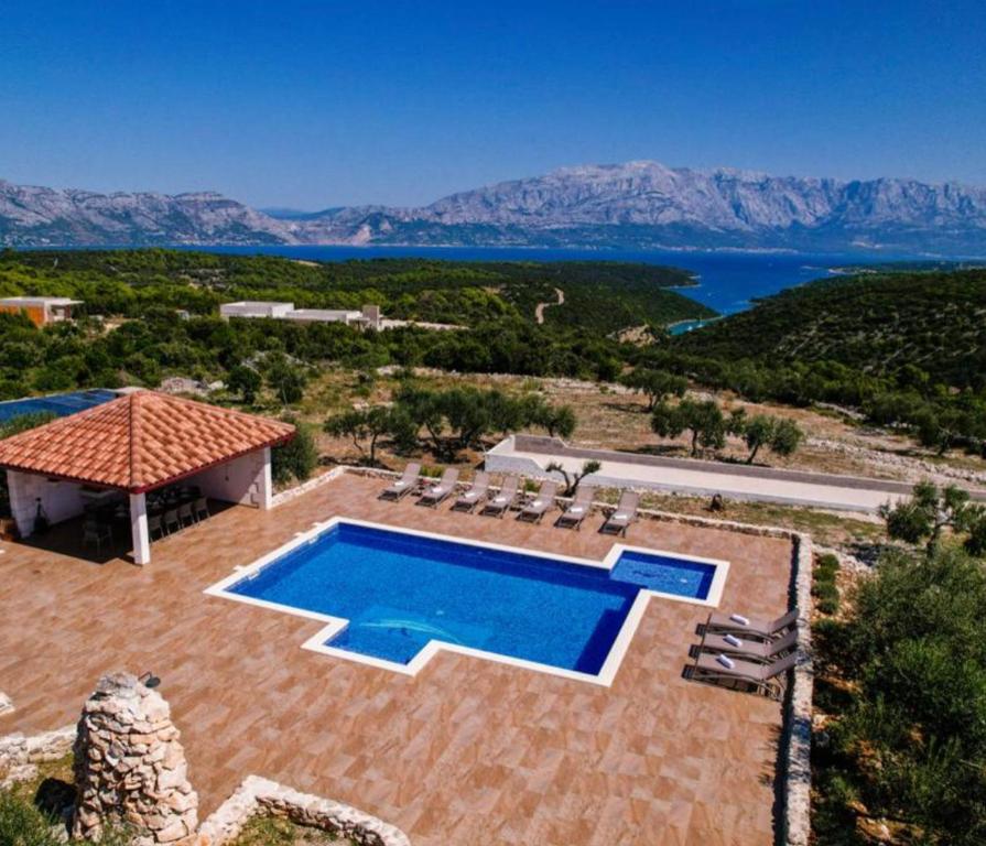 uma vista aérea de uma casa com piscina em Villa Luisa Pucisca - 2 Häuser, 6 Schlafzimmer Insel Brac - Pool, Grill, Kamin, Tischtennis, Boot em Pucisca