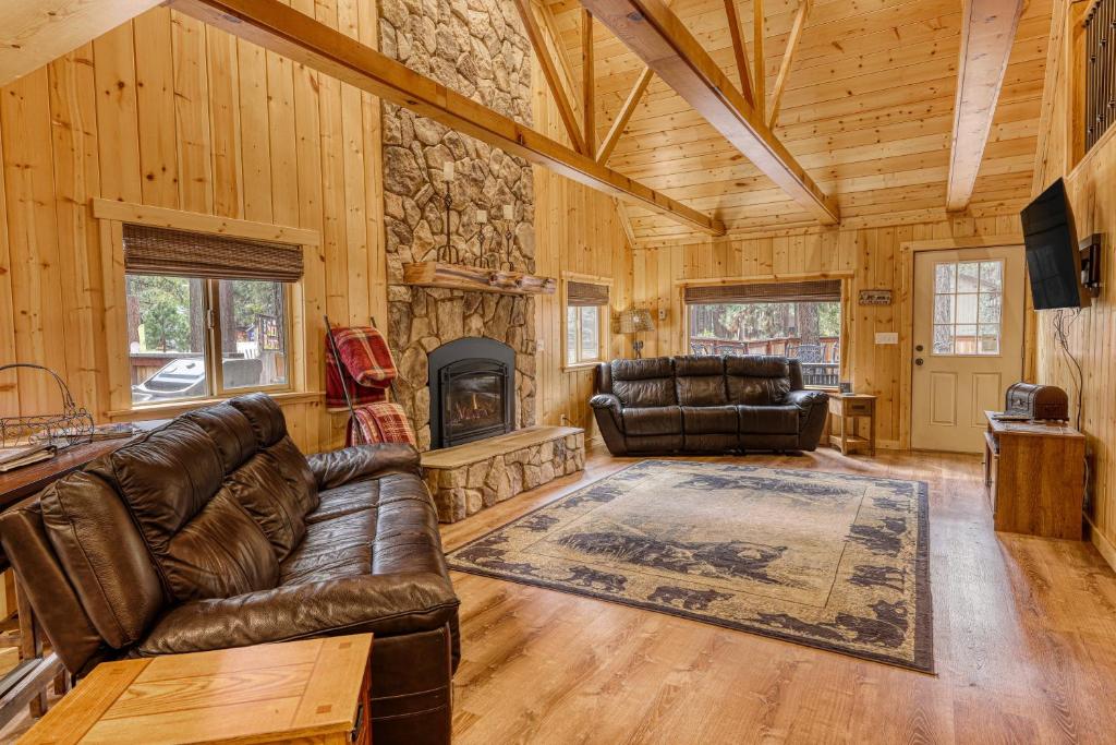 sala de estar con muebles de cuero y chimenea de piedra. en Black Bear Hideaway, en South Lake Tahoe