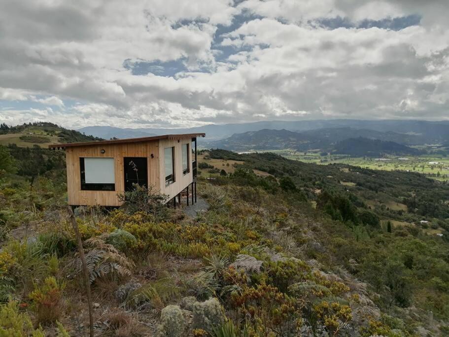 uma pequena casa sentada no topo de uma colina em Mountain Glamping - Nature and Relax em Fúquene
