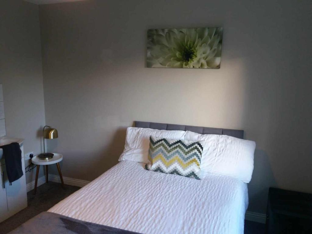 ein Schlafzimmer mit einem Bett mit einer Blume an der Wand in der Unterkunft Dún Eoin Carrigaline in Carrigaline