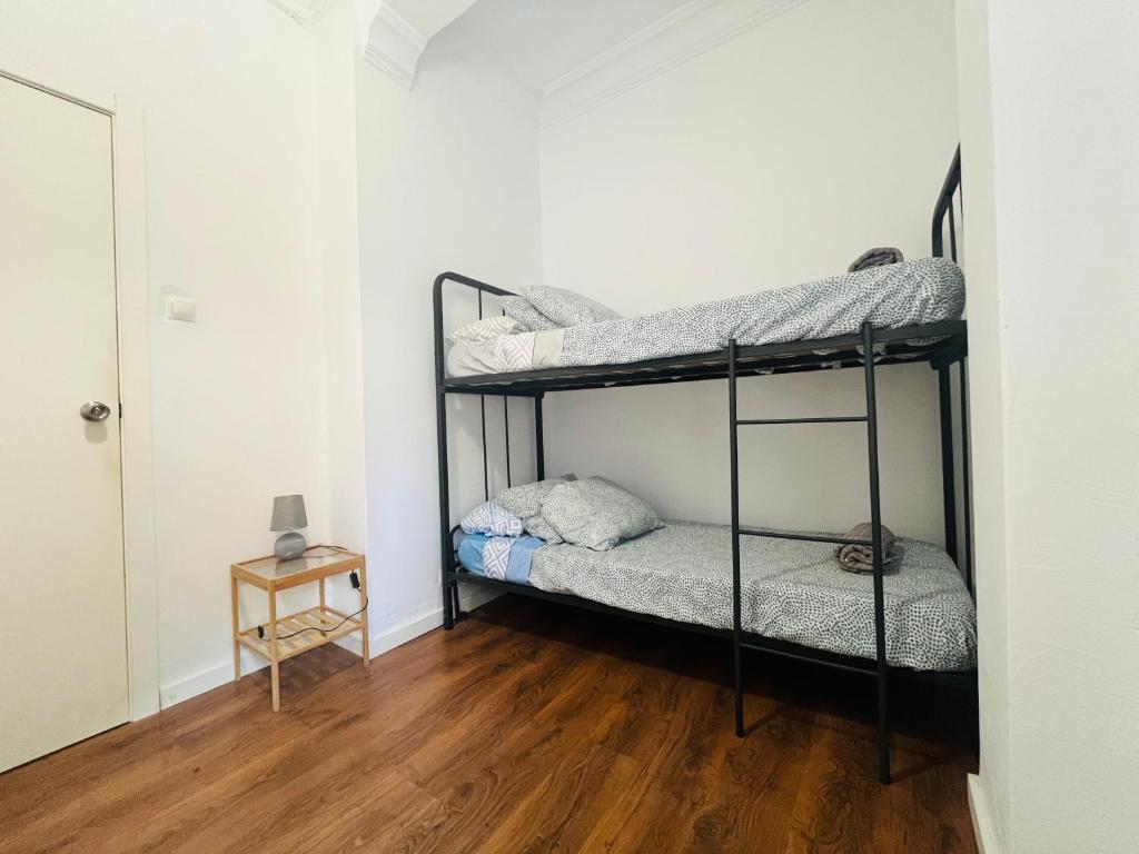 バレンシアにあるPeres i Valero Habitaciones en Piso Compartidoの二段ベッド2組が備わるウッドフロアの客室です。