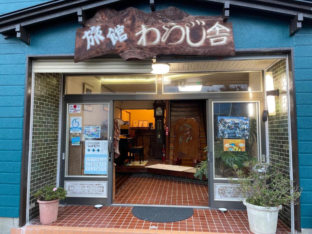 un frente de tienda con un cartel sobre la puerta en Ryokan Warajisha - Vacation STAY 80171v, en Goto