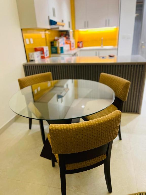 a glass table with two chairs and a counter at Hill Top Holiday Homes Rental in Dubai
