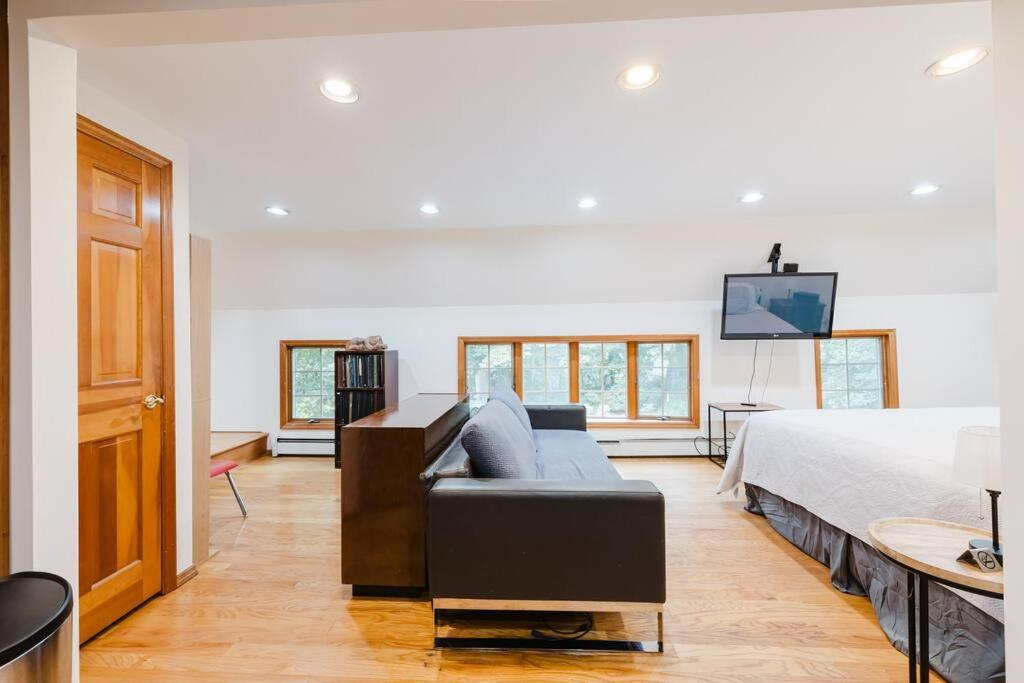 um quarto com uma cama, um sofá e uma televisão em Private estate apartment. em Glen Head