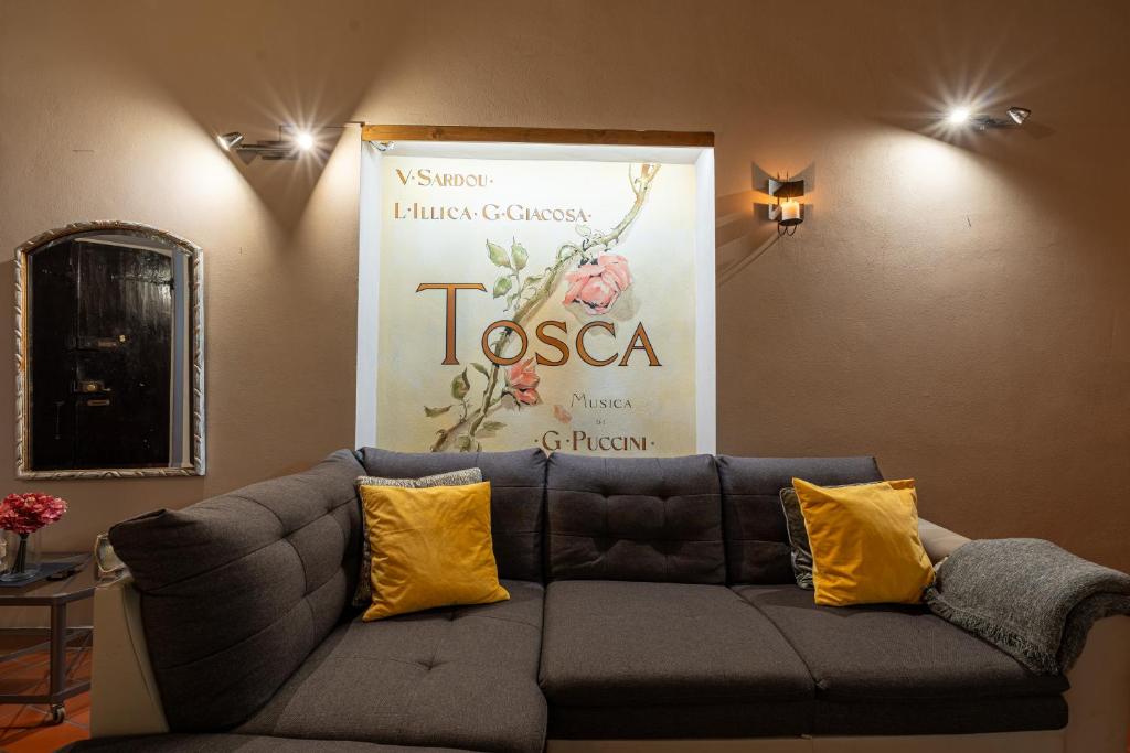 een bank in een kamer met een grote poster aan de muur bij Apartment Anfiteatro in Lucca