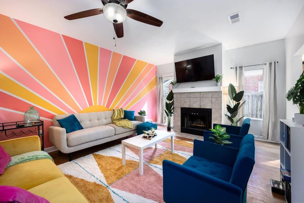 a living room with a couch and a colorful wall at Your UF Getaway: 1 Block from Campus - 4 BD Haven in Gainesville