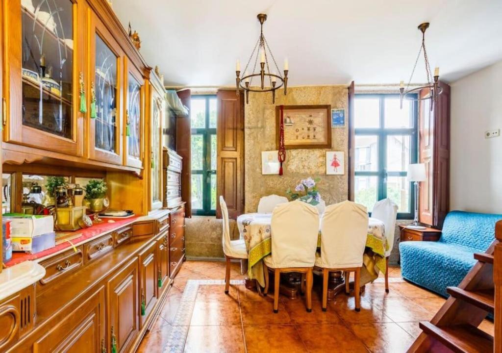 uma cozinha e sala de jantar com mesa e cadeiras em House CONTU1000 em Porto