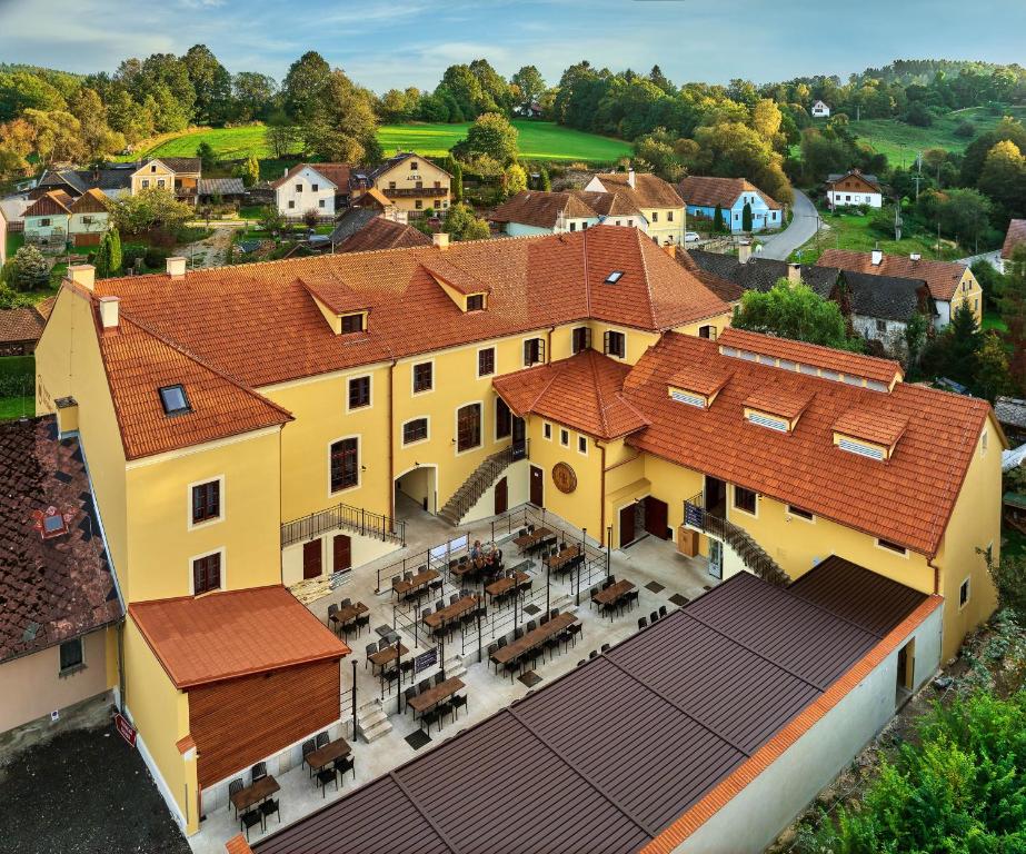 an aerial view of a large yellow building with red roofs at Pivovar Rožmberk in Rožmberk nad Vltavou