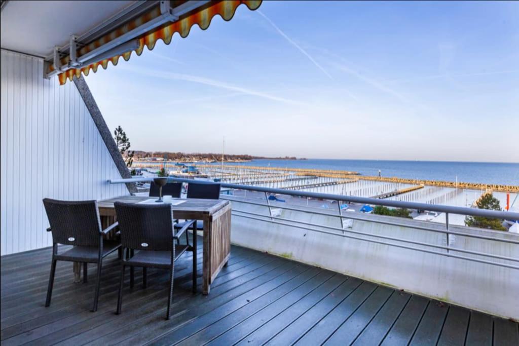 a balcony with a table and chairs on the beach at Panoramablick und den Strand direkt vor der Tür in Kiel