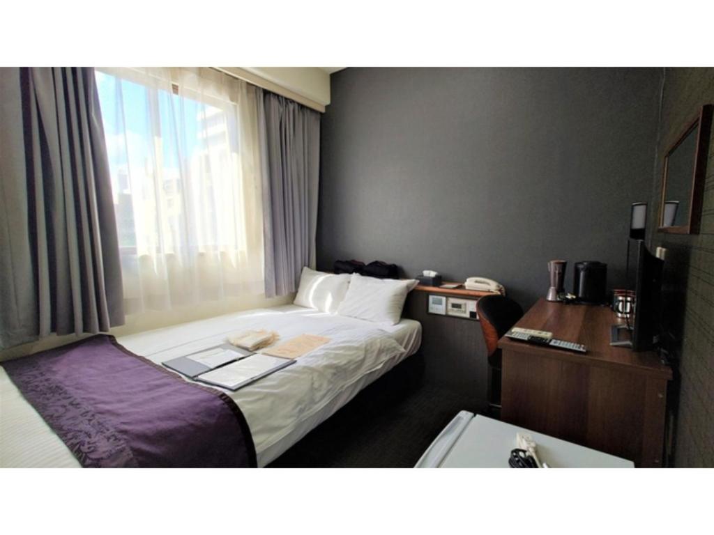a hotel room with a bed and a window at Hotel Area One Oita - Vacation STAY 99711v in Oita