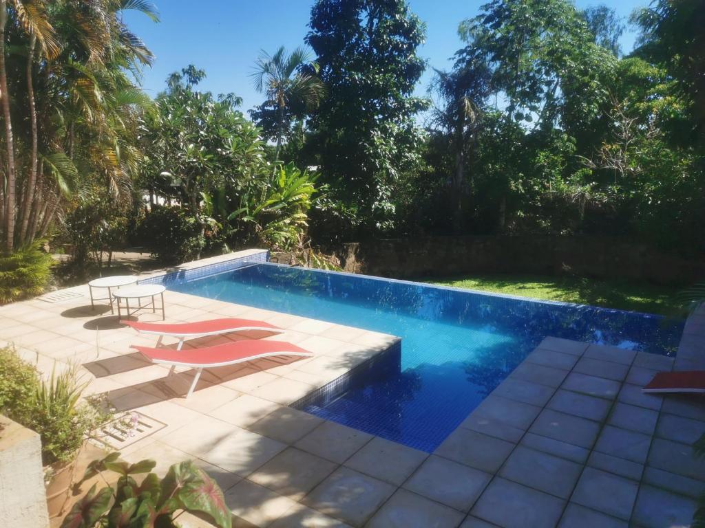 una piscina con 2 tumbonas y una piscina en Granja Relax en Itauguá