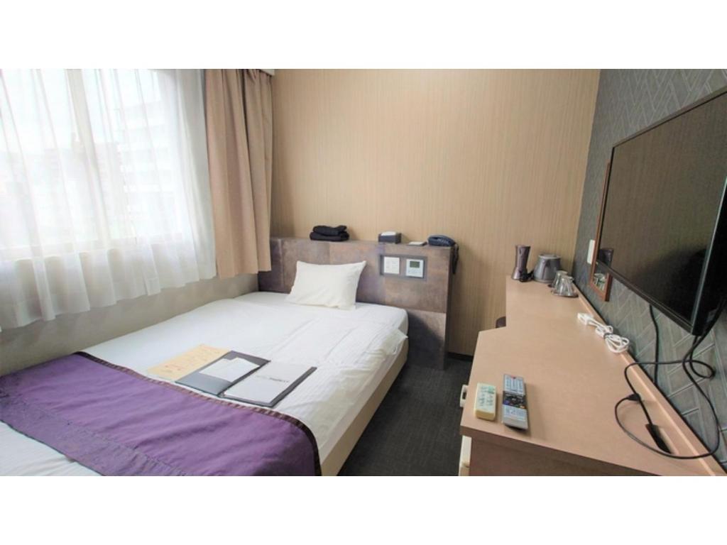 um quarto de hotel com uma cama e uma televisão em Hotel Area One Oita - Vacation STAY 99735v em Oita