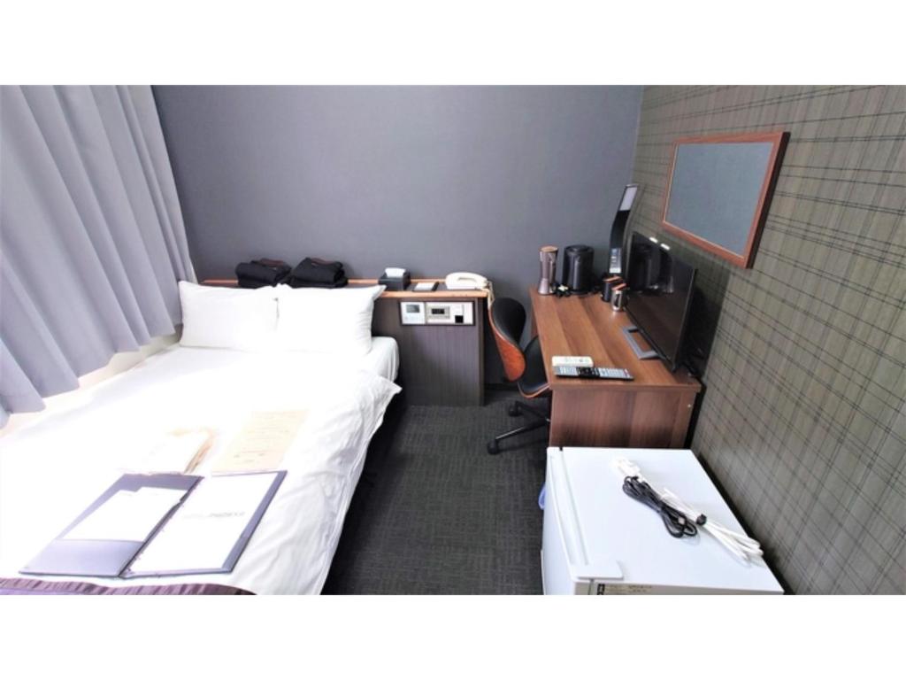 a room with two beds and a desk with a computer at Hotel Area One Oita - Vacation STAY 99724v in Oita