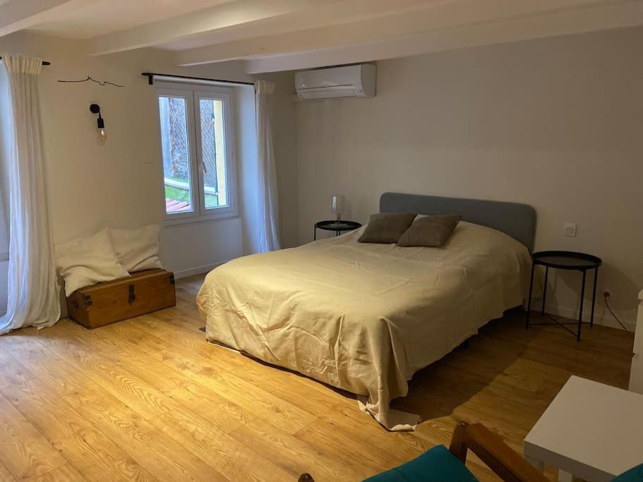 une chambre avec un lit et une grande fenêtre dans l'établissement Charmant studio Vauban, à Marseille