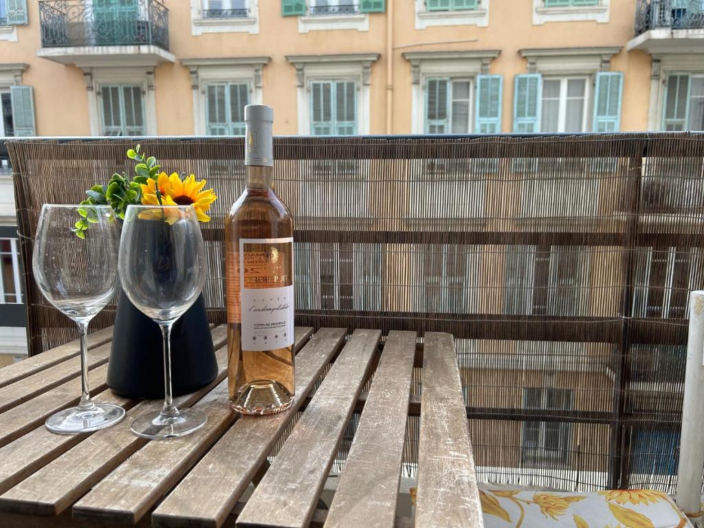 a bottle of wine sitting on a wooden table with a glass at Studio lumineux avec balcon à proximité de la mer in Nice