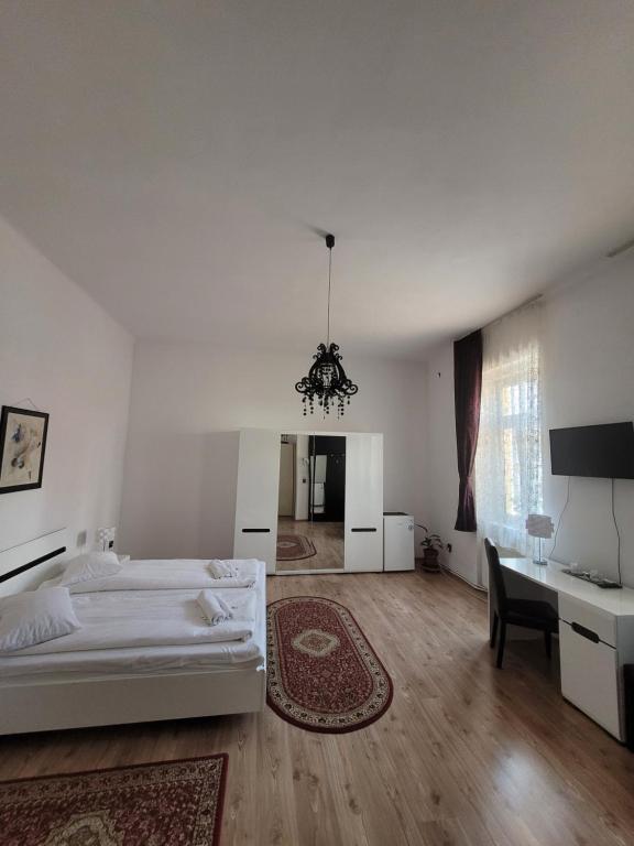 a white bedroom with a bed and a desk at Pensiunea Boema in Cluj-Napoca