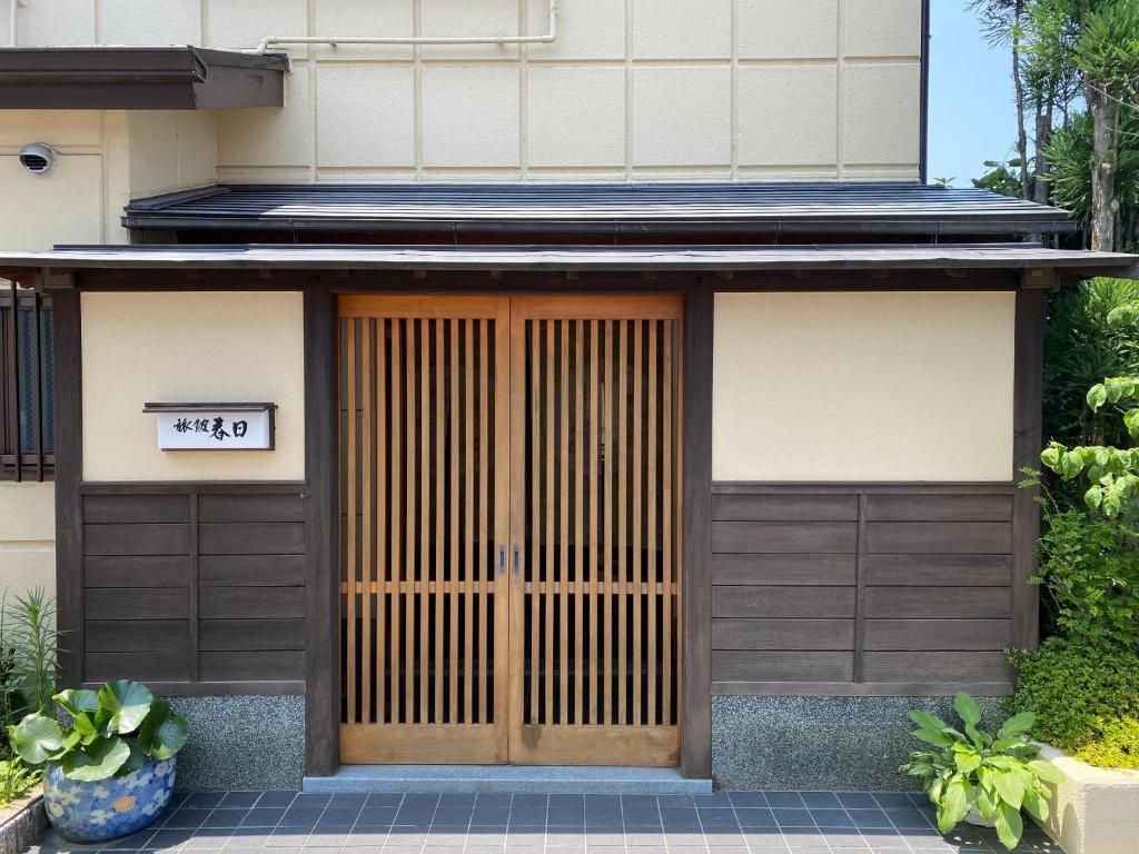 ein Haus mit einer Holztür mit einem Schild darauf in der Unterkunft Ryokankasuga - Vacation STAY 90832v in Nabari