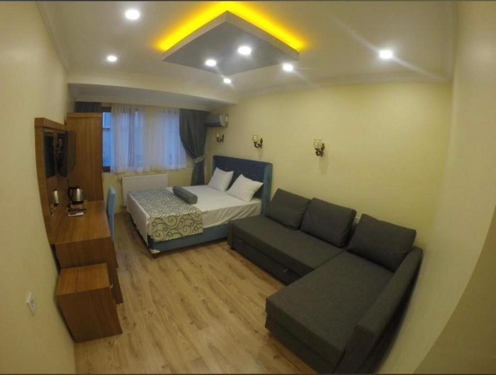 a small living room with a couch and a bed at Riverland Suites Apart Hotel in Istanbul