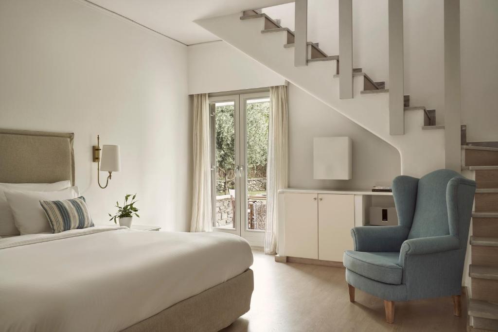 a bedroom with a bed and a blue chair at Yria Island Boutique Hotel & Spa in Parasporos