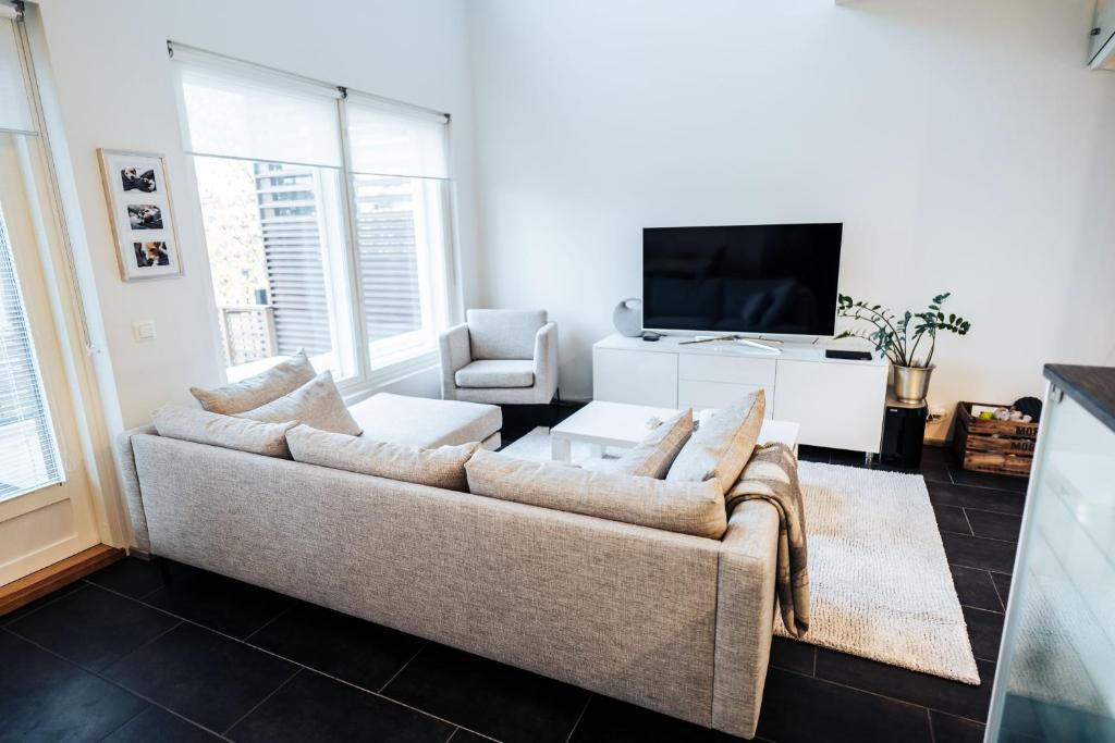 a living room with a couch and a tv at Apartment next to Ounasvaara and city centre in Rovaniemi