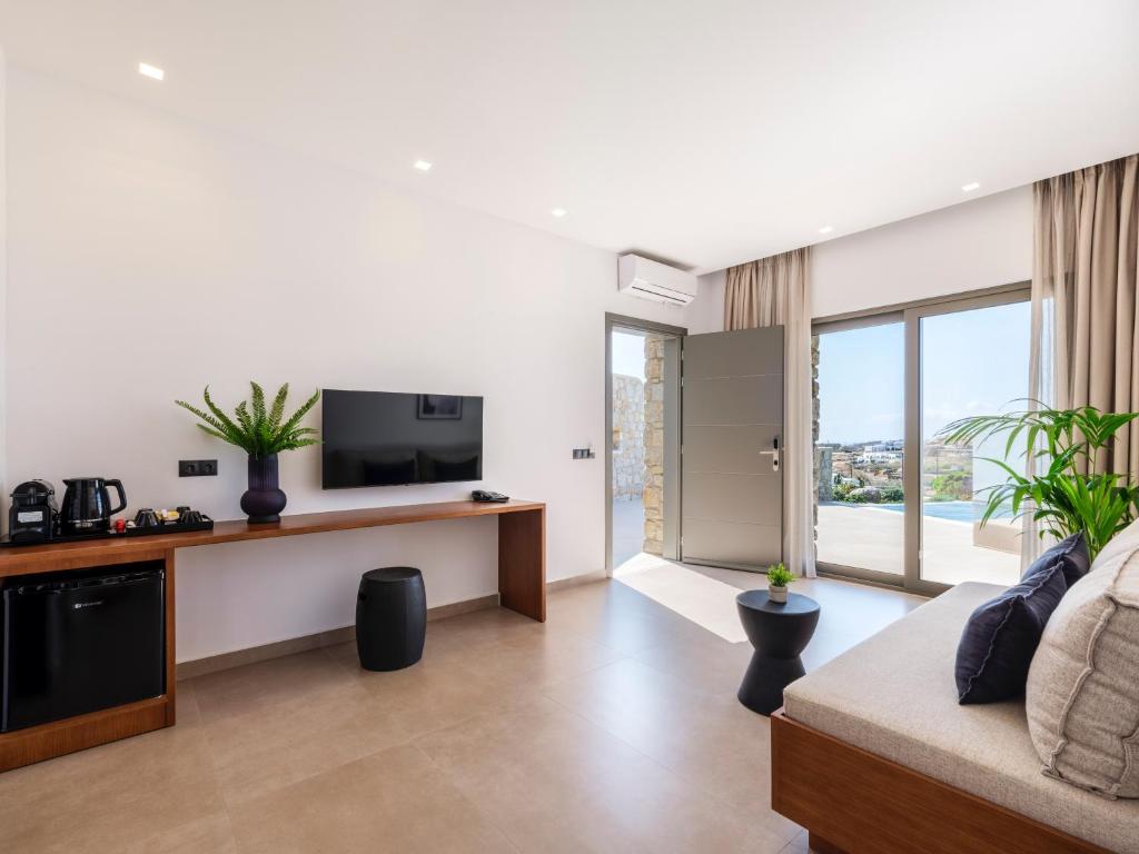 a living room with a television and a couch at Villa Evi & Suites in Mikonos