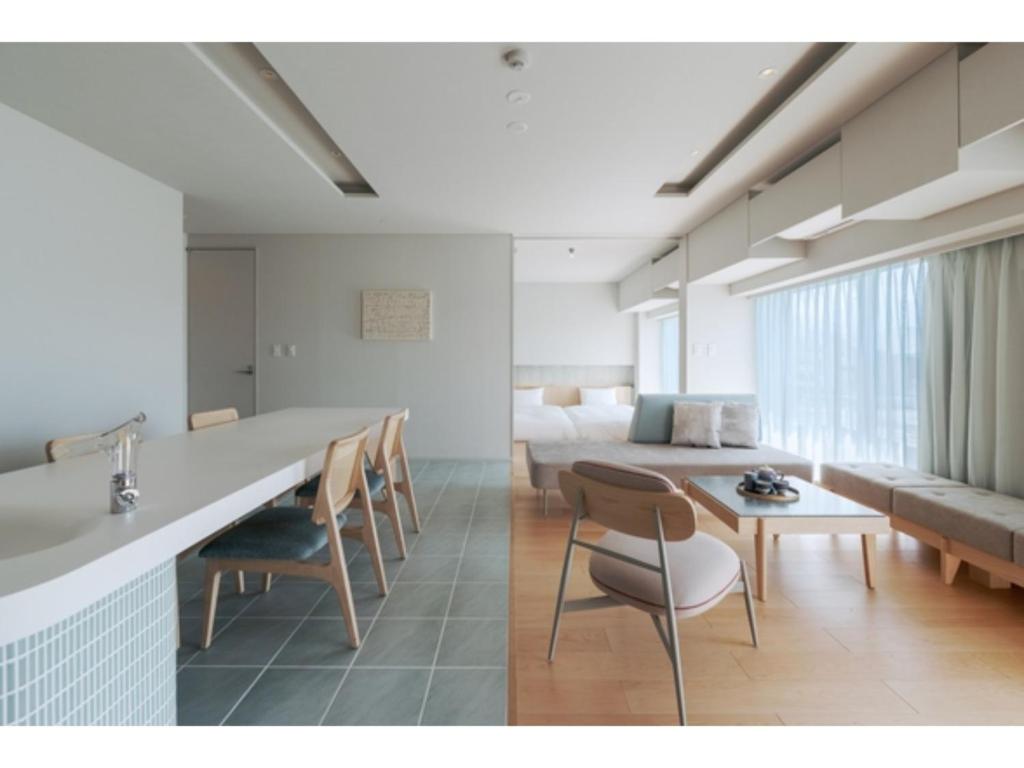 Habitación con cama, mesa y sillas. en ITOMACHI HOTEL 0 - Vacation STAY 97802v, en Saijo