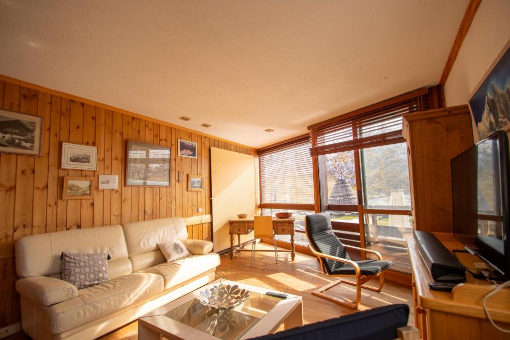 a living room with a couch and a table at Tignes Le Lac - Appartement au pied des pistes (6 personnes) in Tignes