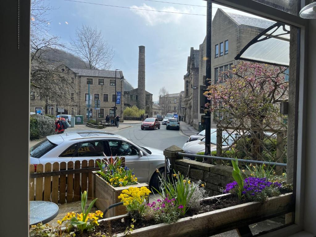 uma vista para a rua a partir de uma janela com flores em Bonsalls Central Hebden Bridge em Hebden Bridge