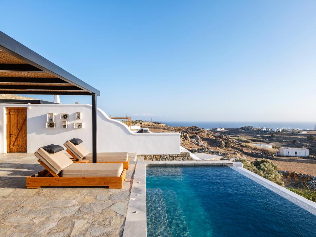 a villa with a swimming pool and a view of the ocean at Villa Evi & Suites in Mikonos