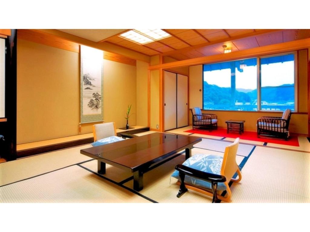 uma sala de jantar com mesa, cadeiras e janelas em Asanoya - Vacation STAY 01715v em Yumura