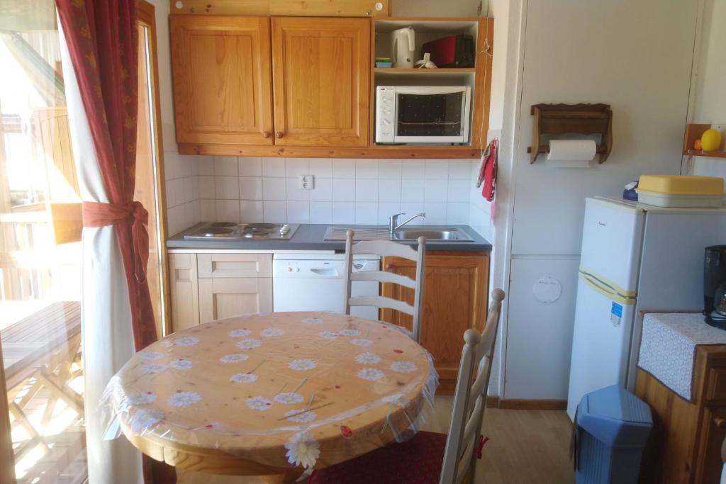 a small kitchen with a table and a sink at Super Devoluy Cosy apartment close to the slopes in Le Dévoluy