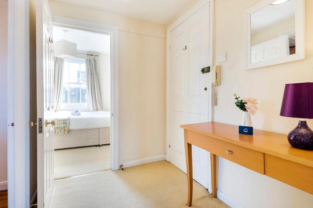 Pokój ze stołem i lustrem oraz sypialnią w obiekcie Cosy Marylebone Flat w Londynie