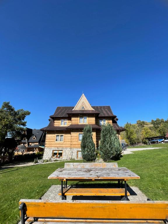 una mesa de picnic de madera frente a una casa en Anna i Franciszek Żegleń Maćkulok, en Małe Ciche