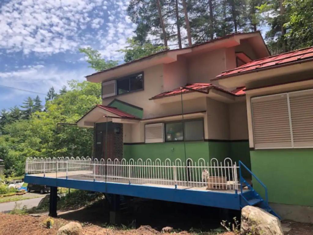 uma casa com um alpendre com uma cerca em Hinata Sanso - Vacation STAY 02668v em Azumino